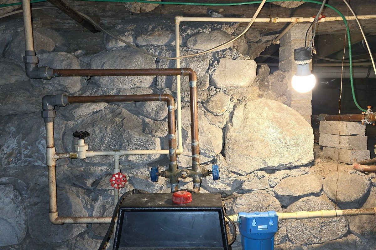 Accessible copper supply lines, valves, and filtration equipment in a residential utility area